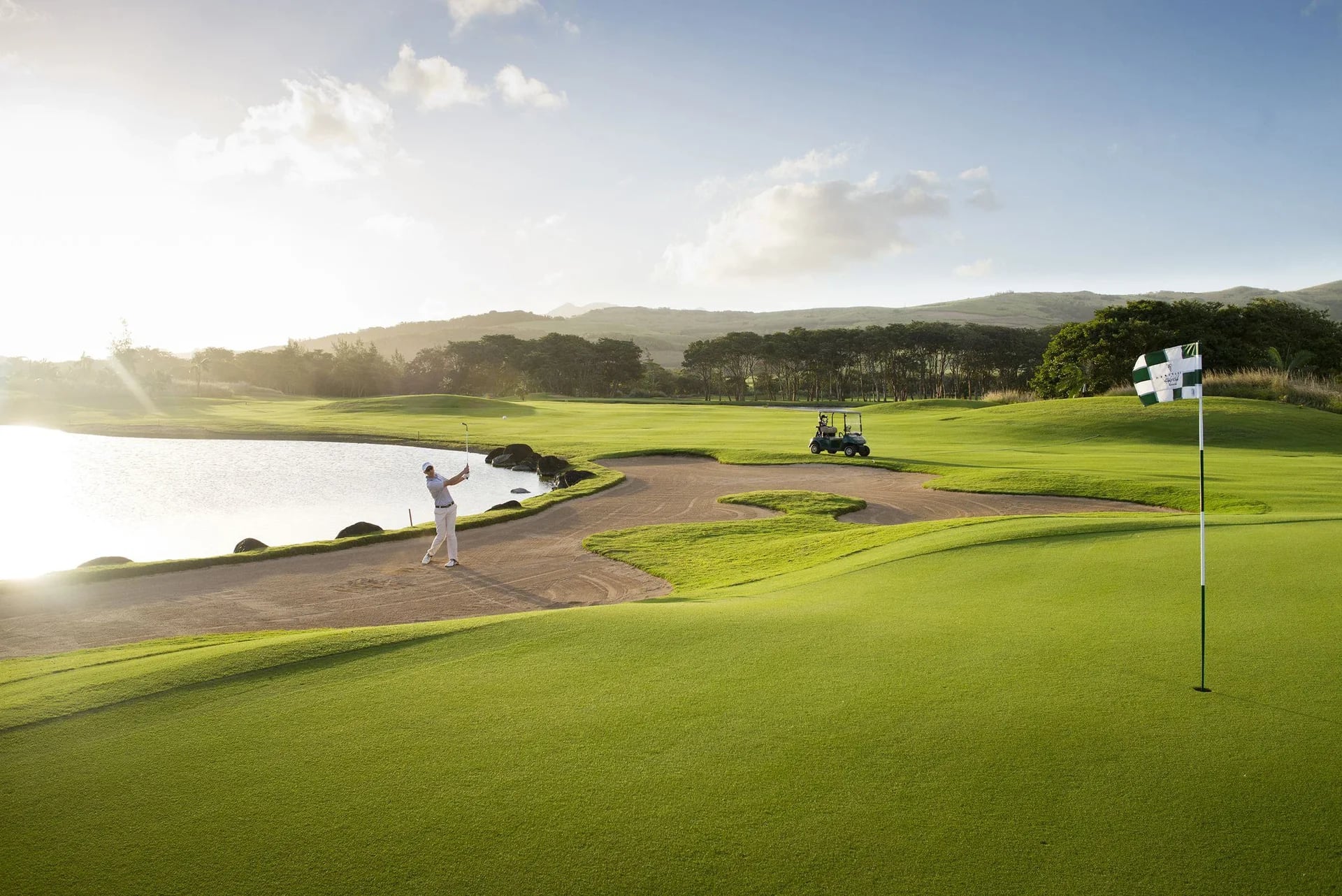 A golfer playing the championship course at Mira Verde in late afternoon light